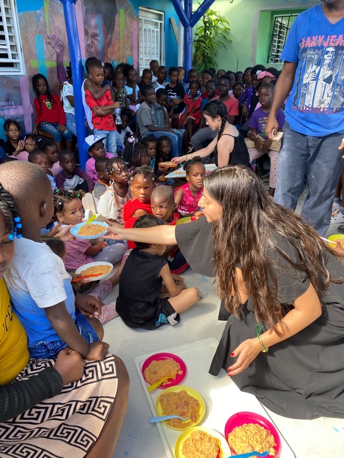 A volunteer handing a plate to the children