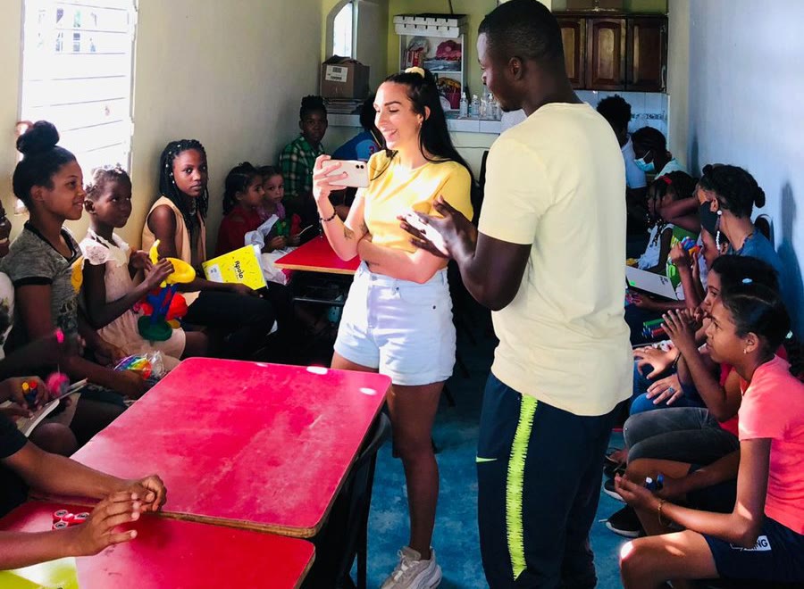 Two volunteers lead an activity with the children seated in the classroom